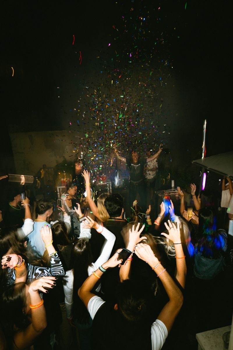 Nightlife crowd celebrating beneath confetti